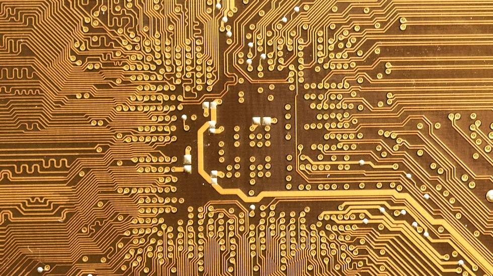 Detailed macro view of gold conductive traces on advanced semiconductor substrate representing modern transistor interconnect technology